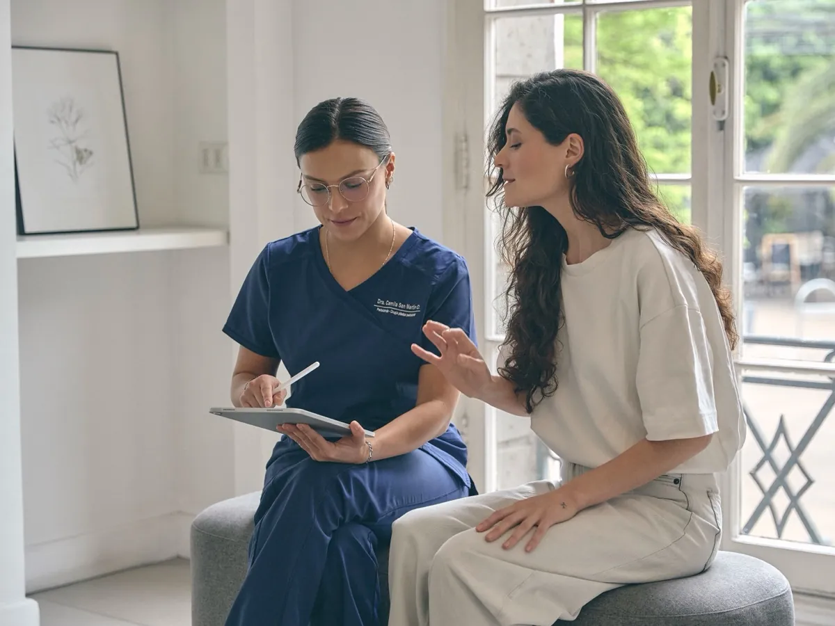 Especialista en periodoncia revisando el diagnóstico en una tablet junto a la paciente
